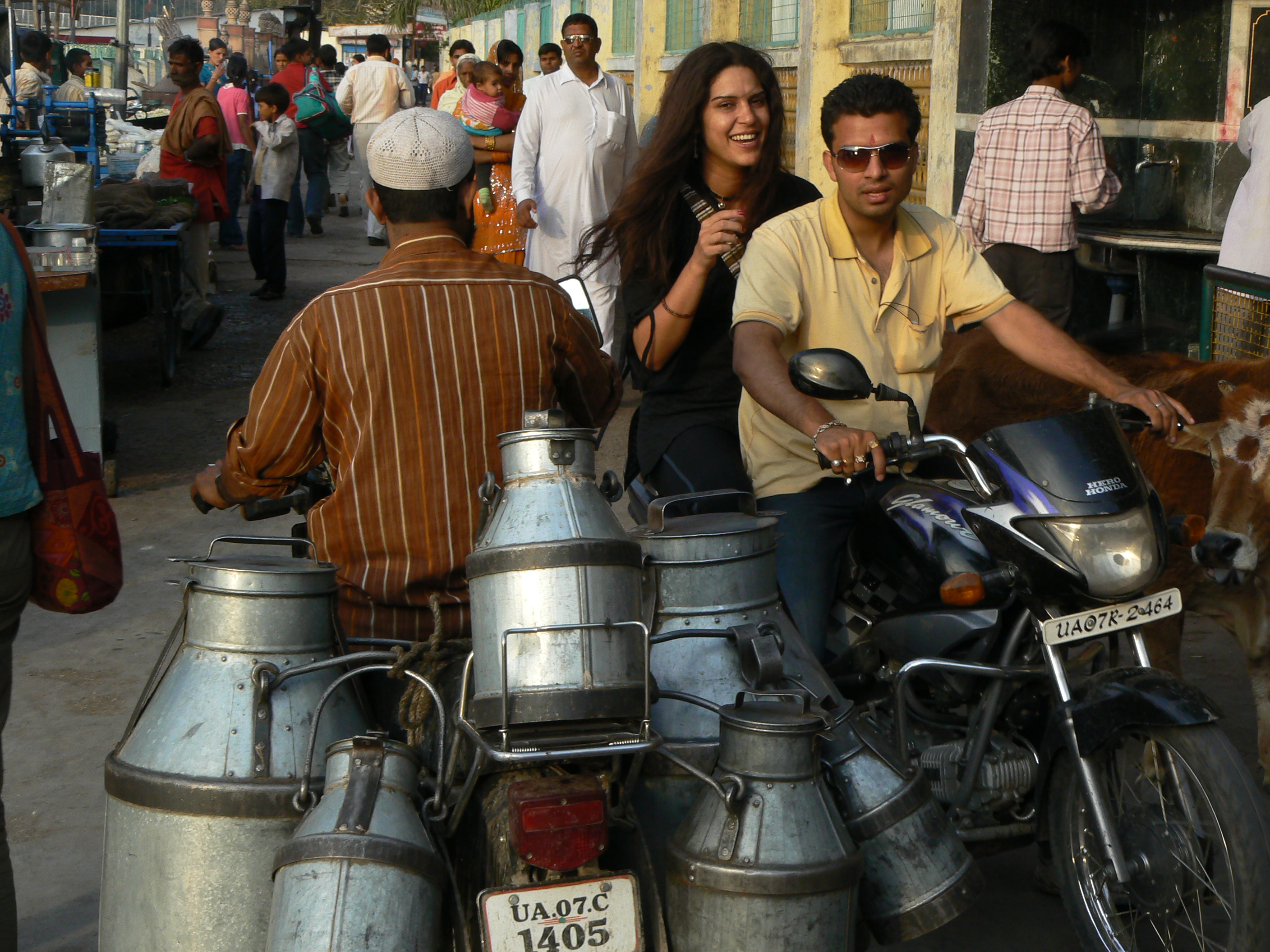 Un porteur de lait a moto croise un scooter dans la ville sainte